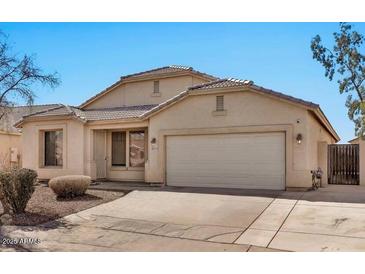 Charming single-story home featuring a well-maintained yard, neutral stucco, and a two-car garage on a sunny day at 10775 W Davis Ln, Avondale, AZ 85323