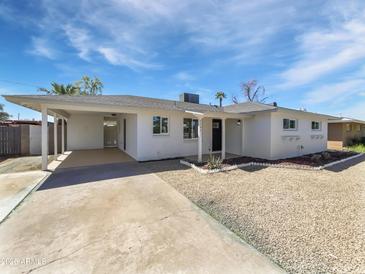 Charming single-story home featuring a covered carport, low maintenance landscaping, and freshly painted white exterior at 2201 W Avalon Dr, Phoenix, AZ 85015