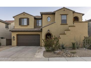Charming two-story home showcasing a brown two-car garage and beautiful desert landscaping at 3911 E Rockingham Rd, Phoenix, AZ 85050