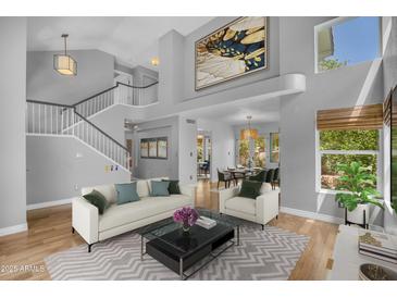 Bright, open-concept living room with staircase, high ceilings, and view into the dining area at 3932 W Rene Dr, Chandler, AZ 85226