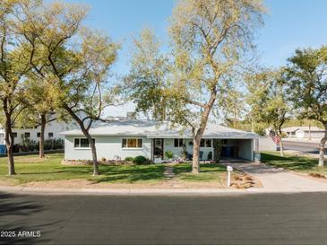Charming single-story home with a well-maintained lawn and mature shade trees enhancing the curb appeal at 4332 E Calle Redonda St, Phoenix, AZ 85018