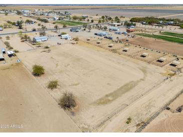 Expansive aerial view of the fenced property with stalls and plenty of open space at 49853 W Jean Dr, Maricopa, AZ 85139