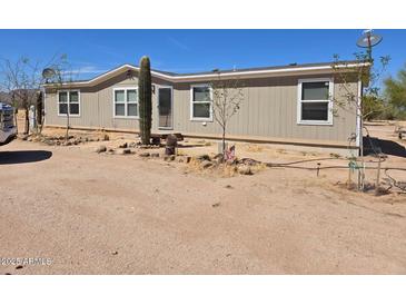 View of a single-story home with neutral paint, desert landscaping, and a satellite dish at 52150 W Cardinal S Rd, Maricopa, AZ 85139