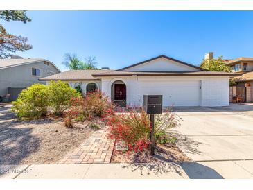 Charming single-story home with a well-manicured lawn and a classic white brick facade at 5325 W Desert Hills Dr, Glendale, AZ 85304