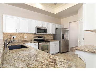Modern kitchen features stainless steel appliances, granite countertops, and white cabinetry at 10316 E Rimrock Loop, Gold Canyon, AZ 85118