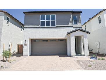 Charming two-story home featuring gray and white paint, brick driveway, and attached two car garage at 2442 W Rowel Rd, Phoenix, AZ 85085