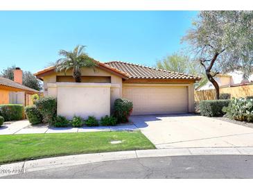 Inviting home exterior features a two-car garage, tile roof, desert landscaping, and mature shade trees at 13390 N 95Th Way, Scottsdale, AZ 85260