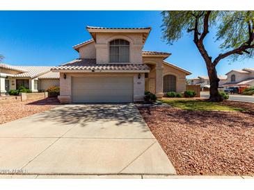 Charming two-story home featuring a neutral stucco exterior, tile roof, and a spacious two-car garage at 13711 N 81St Ave, Peoria, AZ 85381