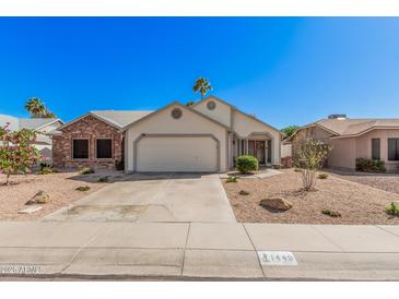 Charming single-Gathering home with desert landscaping and a two-car garage on a clear day at 1449 E Kent Ave, Chandler, AZ 85225