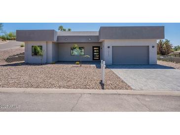 Modern single-story home featuring a gray stucco exterior, desert landscaping, and a two-car garage at 16405 N Cobblestone Ln, Fountain Hills, AZ 85268