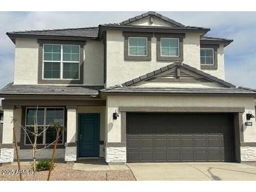 Charming two-story home featuring a gray two-car garage and a blue front door at 17808 W Sanna St, Waddell, AZ 85355
