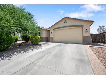 Charming single-Gathering home featuring a well-maintained lawn and an attached two-car garage with a long driveway at 2167 W Ethan Ct, San Tan Valley, AZ 85144