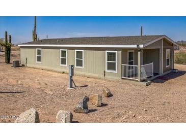 Inviting single-story home featuring desert landscaping and a covered front porch at 25958 W Muirfield Dr, Morristown, AZ 85342