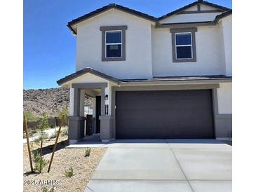 Charming two-story home featuring neutral paint, a dark gray garage door and desert landscaping at 9807 S 11Th St, Phoenix, AZ 85042