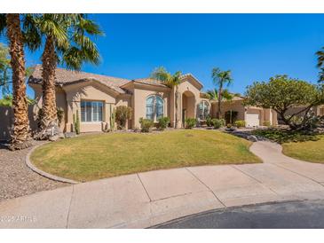Charming home featuring desert landscaping, a paver walkway, and a beige exterior at 11224 E Carol Ave, Scottsdale, AZ 85259
