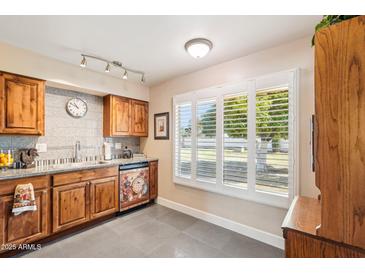 Bright kitchen with granite countertops and custom-painted dishwasher at 17885 N 99Th Dr, Sun City, AZ 85373