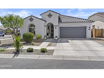 Charming stucco home featuring a tile roof, arched entry, and a well-manicured front yard at 24540 N 144Th Ave, Surprise, AZ 85387