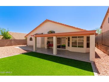 An airy back patio, complete with artificial grass and a tiled seating area, is great for entertaining at 2904 E Ludlow Dr, Phoenix, AZ 85032