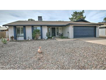 Charming single-story home featuring a low-maintenance gravel yard and a two-car garage at 815 E Paradise Ln, Phoenix, AZ 85022
