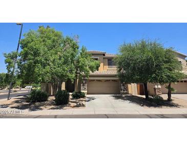 Well-maintained two-story home featuring a two-car garage and a driveway, surrounded by lush landscaping and blue sky at 1101 S Hazel St, Gilbert, AZ 85296