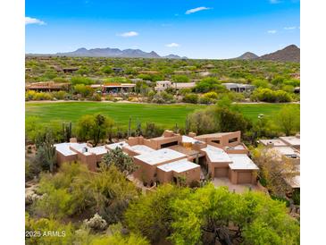 Desert home with a tan exterior, beautiful landscaping, and mountain views at 1637 N Quartz Valley Rd, Scottsdale, AZ 85266