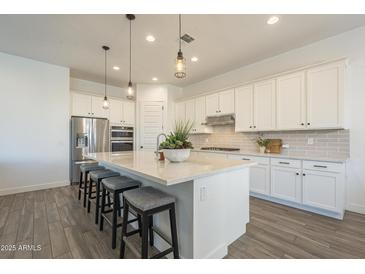 Beautiful kitchen with pendant lighting, stainless steel appliances, and a large center island at 10134 E Supernova Dr, Mesa, AZ 85212
