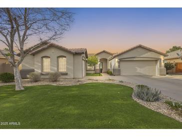Charming single-story home featuring a low-maintenance xeriscape yard with artificial turf and mature landscaping at 11502 E Rafael Ave, Mesa, AZ 85212