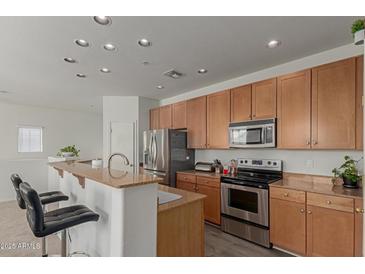 Bright kitchen features stainless appliances, wood cabinets, granite counters and a breakfast bar with seating at 1330 S Aaron -- # 218, Mesa, AZ 85209
