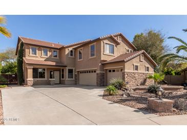 Stunning two-story home with a spacious driveway and a well-maintained front yard featuring stone accents at 13514 W Banff Ln, Surprise, AZ 85379