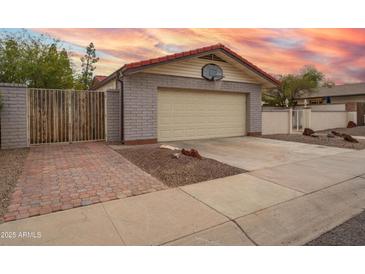 Charming home exterior featuring a two-car garage and basketball hoop at 1523 W Glenn Dr, Phoenix, AZ 85021
