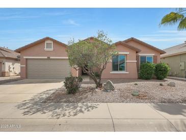 Charming single-story home featuring a low-maintenance desert landscaped front yard and attached two car garage at 18051 W Port Royale Ln, Surprise, AZ 85388