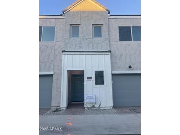 Stylish townhome exterior showcasing a modern entrance with a gray door and neutral stucco facade at 2244 W Laurie Ln, Phoenix, AZ 85021