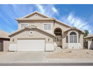 Charming two-story home featuring neutral stucco, an arched entryway, and a well-manicured front yard at 2806 E Pontiac Dr, Phoenix, AZ 85050