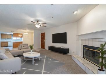 Bright living room featuring a fireplace, ceiling fan and access to the kitchen at 3031 N Civic Center Plz # 255, Scottsdale, AZ 85251