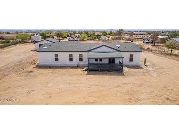 Inviting single-story home featuring a charming front porch and a well-maintained yard at 30433 W Bellview St, Buckeye, AZ 85396