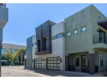 Contemporary townhome featuring a two-car garage, balcony, and modern architectural details at 340 E Osborn Rd # 3, Phoenix, AZ 85012