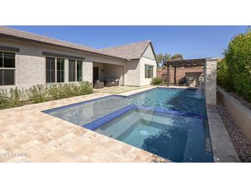 Beautiful backyard pool with tanning ledge, spa, waterfall feature, and outdoor seating area at 3429 E Constance Way, Phoenix, AZ 85042