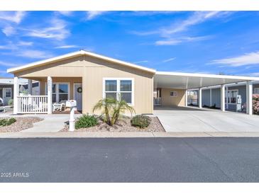 Charming tan home with a covered porch, low maintenance landscaping, and covered parking perfect for Arizona living at 40511 N Birdie St, San Tan Valley, AZ 85140