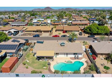 Aerial view of a backyard with a pool, patio, and well-maintained landscaping in a residential neighborhood at 4139 W Anderson Dr, Glendale, AZ 85308