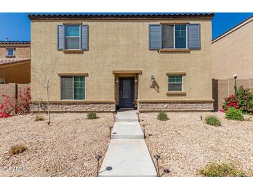 Inviting two-story home with neutral stucco and shutters and well-kept xeriscaped front yard at 8046 W Agora Ln, Phoenix, AZ 85043