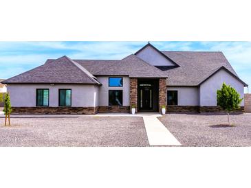 Charming single-story home featuring stone accents, gray stucco, well-manicured landscaping, and a welcoming entryway at 34949 N Donald Way, San Tan Valley, AZ 85140