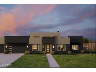 Striking contemporary home boasts clean lines, neutral tones, and lush landscaping against a colorful dusk sky at 5439 E Bloomfield Rd, Scottsdale, AZ 85254