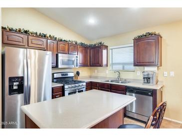 Well-equipped kitchen with stainless steel appliances, dark wood cabinets, and a center island at 4056 E Rock Dr, San Tan Valley, AZ 85143