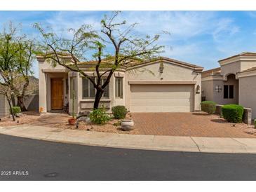 Charming single-story home with a desert-landscaped front yard and brick-paved driveway leading to an attached two-car garage at 12841 N 19Th St, Phoenix, AZ 85022