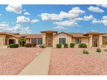 Beautiful single-story home featuring a well-manicured front yard with vibrant bushes and sidewalk at 13630 W Aleppo Dr, Sun City West, AZ 85375