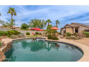 Resort-style pool features a water feature, lush landscaping, a mini-golf, and patio seating for outdoor entertainment at 14374 W Amelia Ave, Goodyear, AZ 85395