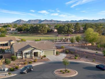 Scenic aerial view of landscaped property, neighborhood, playground and mountains in the distance at 18611 E Raven Dr, Queen Creek, AZ 85142
