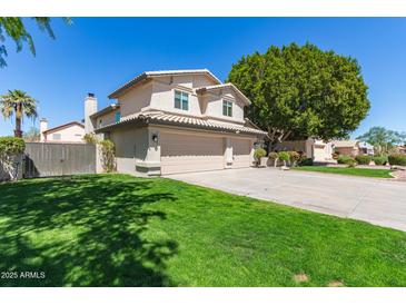 Charming home featuring a large three-car garage, verdant lawn, and established shade trees at 1920 E Belmont Dr, Tempe, AZ 85284