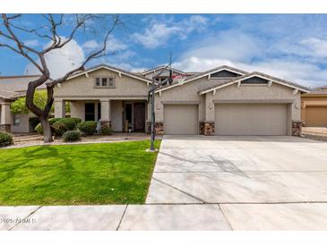 Charming home with a well-maintained lawn, three-car garage, and a basketball hoop on the driveway at 30246 N 123Rd Ln, Peoria, AZ 85383