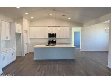 Bright, open kitchen featuring a large island, modern appliances, and stylish white cabinets at 9430 W Sandstone Mountain Dr, Casa Grande, AZ 85194